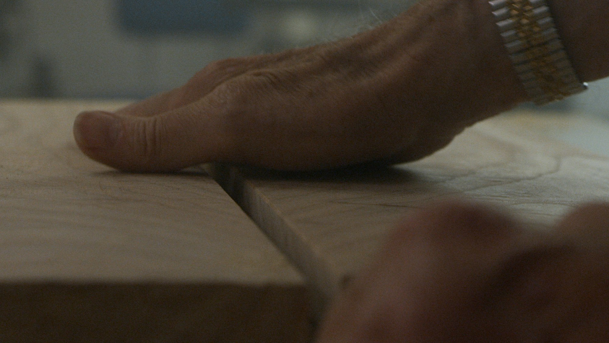 A man's hands on a wooden surface